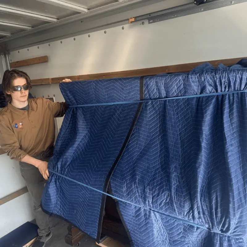 The Room-by-Room Packing Guide for a San Antonio Move 1 Room-by-room packing guide: movers carrying a wrapped item in San Antonio