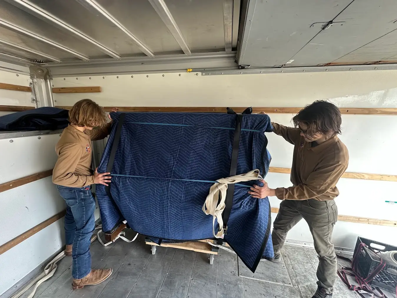 Moving to Another Texas City? Your Intrastate Timeline and Route Guide 1 Movers carrying a wrapped item during a Texas intrastate move