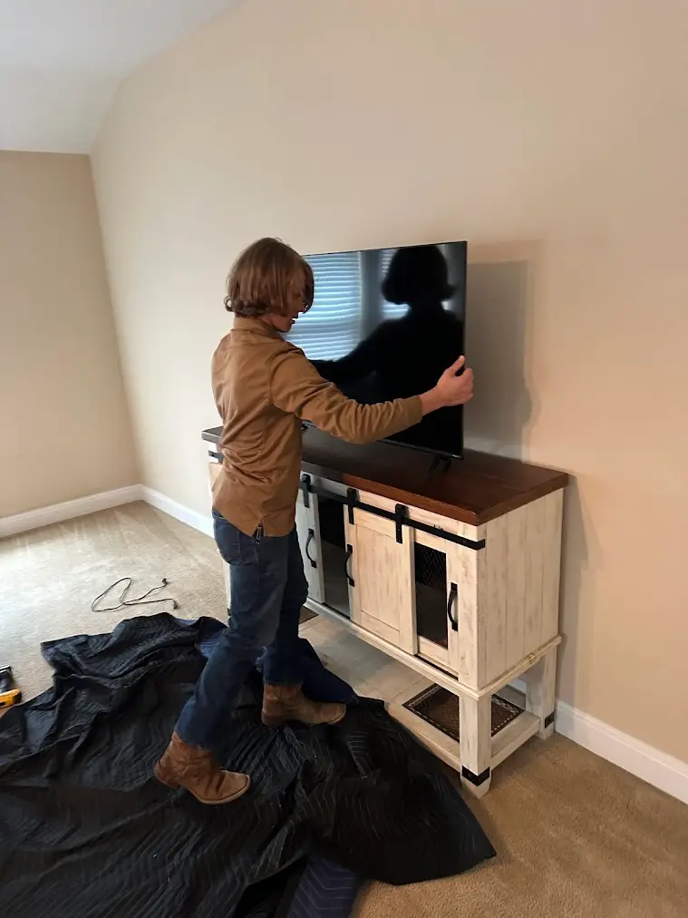 How to Pack Fragile Items Like a Pro 1 How to pack fragile items: movers carefully placing a TV during a San Antonio move