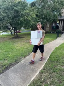Two Step Moving crew member carrying a moving box on moving day in San Antonio, TX