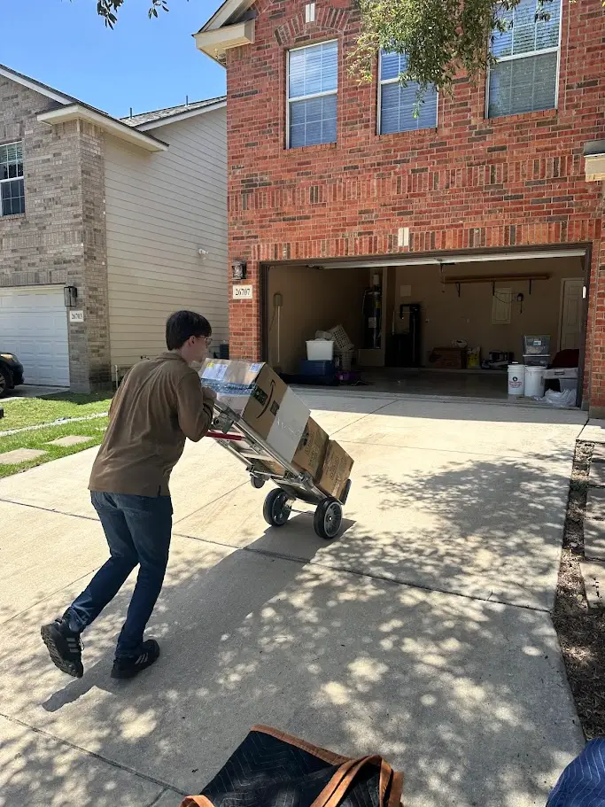 Should You Hire Professional Movers in San Antonio, TX? 2 Two Step Moving crew member using a hand dolly to move boxes for a San Antonio move