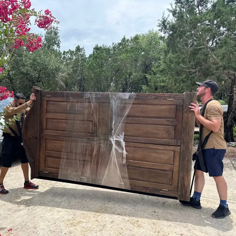San Antonio to Austin Moving Guide: Cost, Timing, and Tips 1 San Antonio to Austin moving guide: movers carrying a wrapped wardrobe
