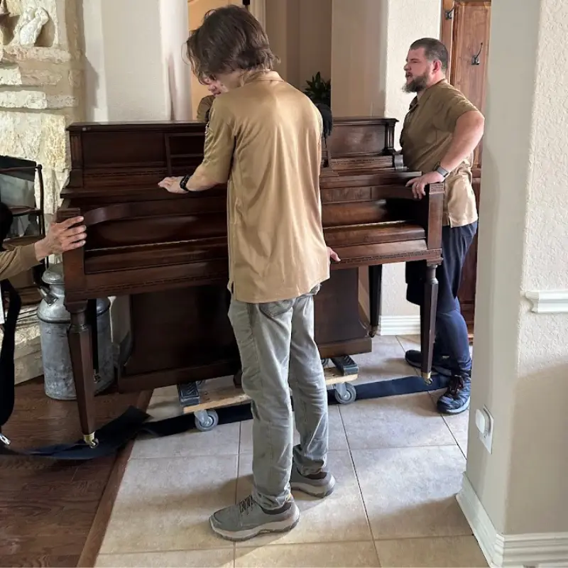 San Antonio to Austin Moving Guide: Cost, Timing, and Tips 2 Movers carrying a dresser during a San Antonio to Austin move