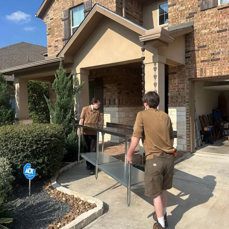Downsizing and Senior Moving Guide for San Antonio 1 Movers carrying a table outdoors during a senior downsizing move in San Antonio